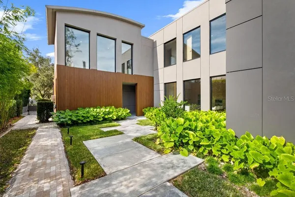 a front view of yellow house with garden