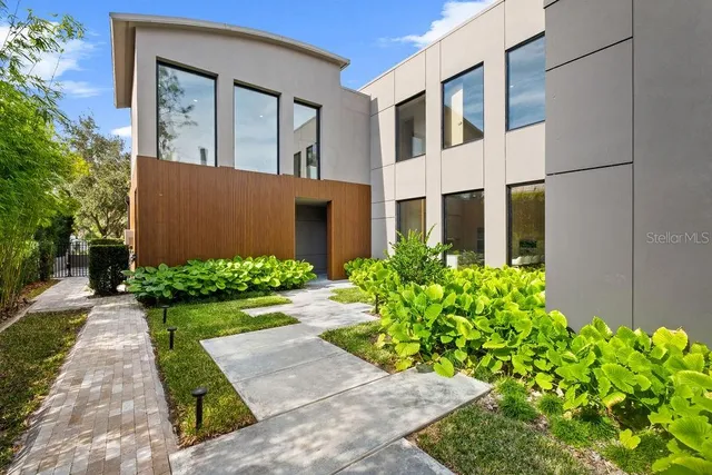 a front view of yellow house with garden