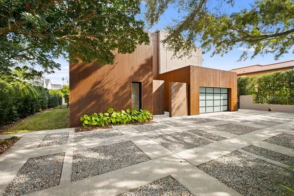 a front view of a house with a yard and potted plants