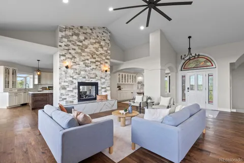 a large kitchen with kitchen island a stove a sink a center island and wooden floor