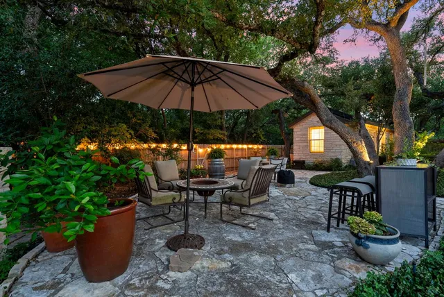 a view of a patio with furniture and a garden