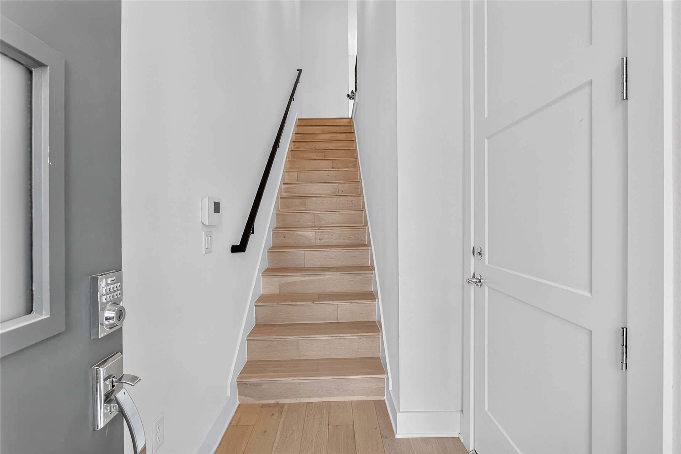 2805 McCurdy Street, Unit 14 Austin, TX 78723 - Photo 8 of 40 Clean lines and light wood flooring define the inviting entry and staircase of this contemporary residence. The 2-car garage entrance door is on the right.