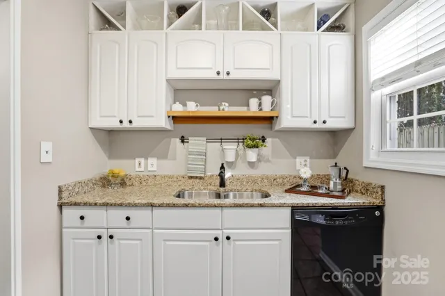 a kitchen with granite countertop a sink stove and cabinets