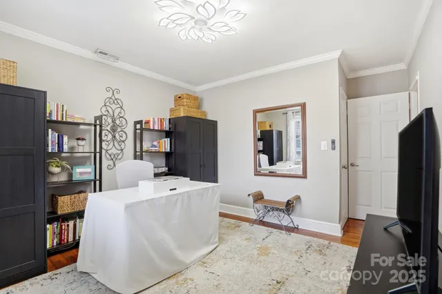 a living room with furniture a flat screen tv and a table