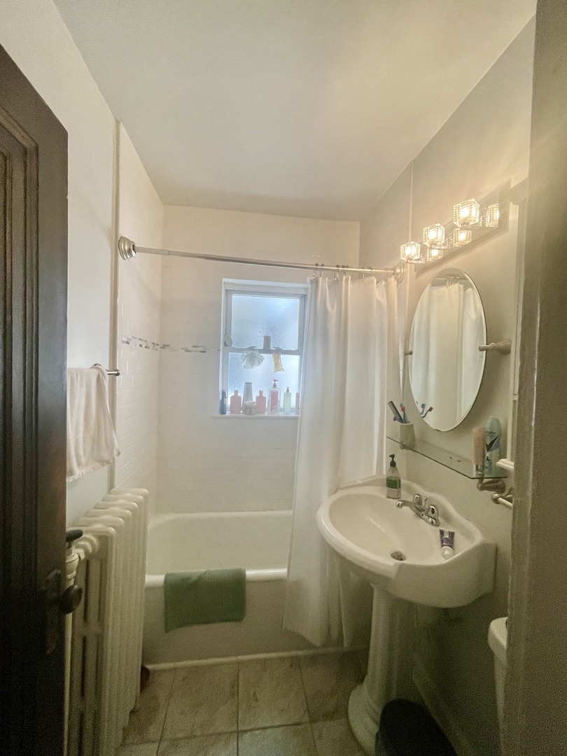 1112 Grove Street, Unit 1B Evanston, IL 60201 - Photo 12 of 14 a bathroom with a sink mirror and a shower