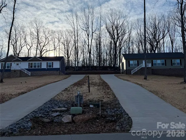 a view of a house with backyard and trees