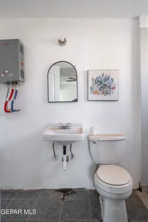 a bathroom with a toilet a sink and mirror