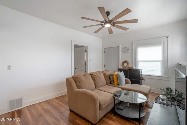a living room with furniture and a wooden floor