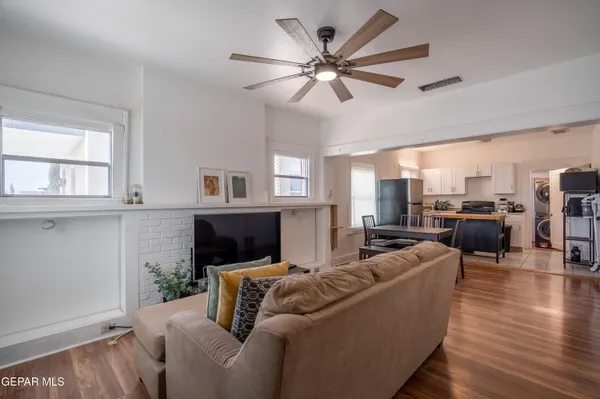 a living room with furniture kitchen view and a window