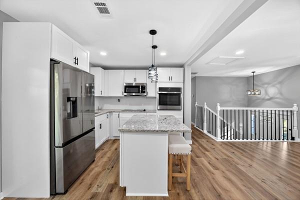 1864 Glen Echo Drive Decatur, GA 30032 - Photo 12 of 38 a kitchen with stainless steel appliances kitchen island granite countertop a refrigerator a stove a sink dishwasher and white cabinets with wooden floor