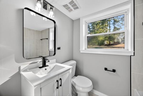 1864 Glen Echo Drive Decatur, GA 30032 - Photo 21 of 38 a bathroom with a toilet a sink a mirror and a window