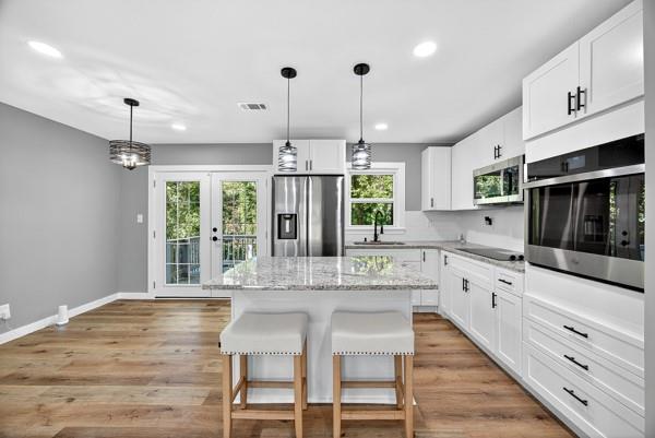 1864 Glen Echo Drive Decatur, GA 30032 - Photo 10 of 38 a kitchen with stainless steel appliances kitchen island granite countertop a stove a sink and white cabinets with wooden floor