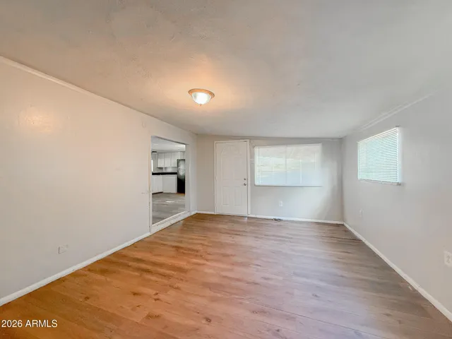 a view of empty room with wooden floor
