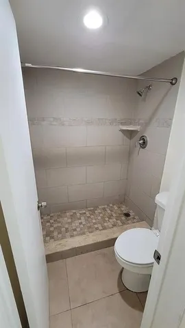 a bathroom with a granite countertop toilet a sink and a shower