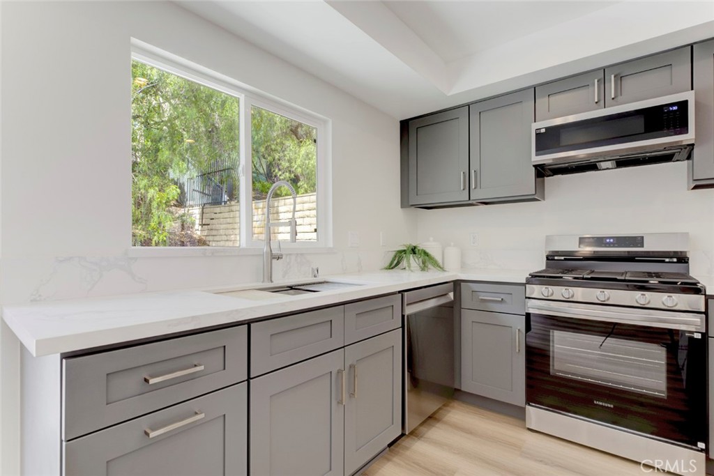 3256 North Frederic Street Burbank, CA 91504 - Photo 14 of 45 a kitchen with a sink stove and microwave