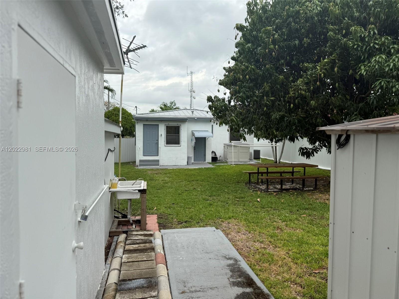 5940 Southwest 2nd Street Miami, FL 33144 - Photo 12 of 22 a backyard of a house with table and chairs