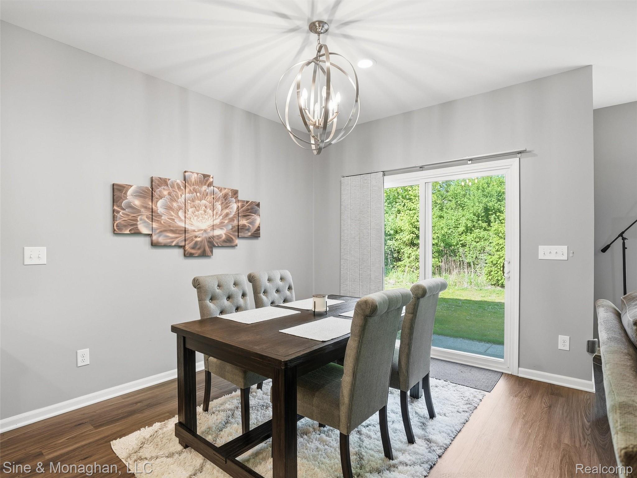 24827 Ivy Road Novi, MI 48375 - Photo 8 of 38 Dining area featuring wood-finish flooring, a contemporary chandelier, and a sliding glass door providing direct access to the backyard