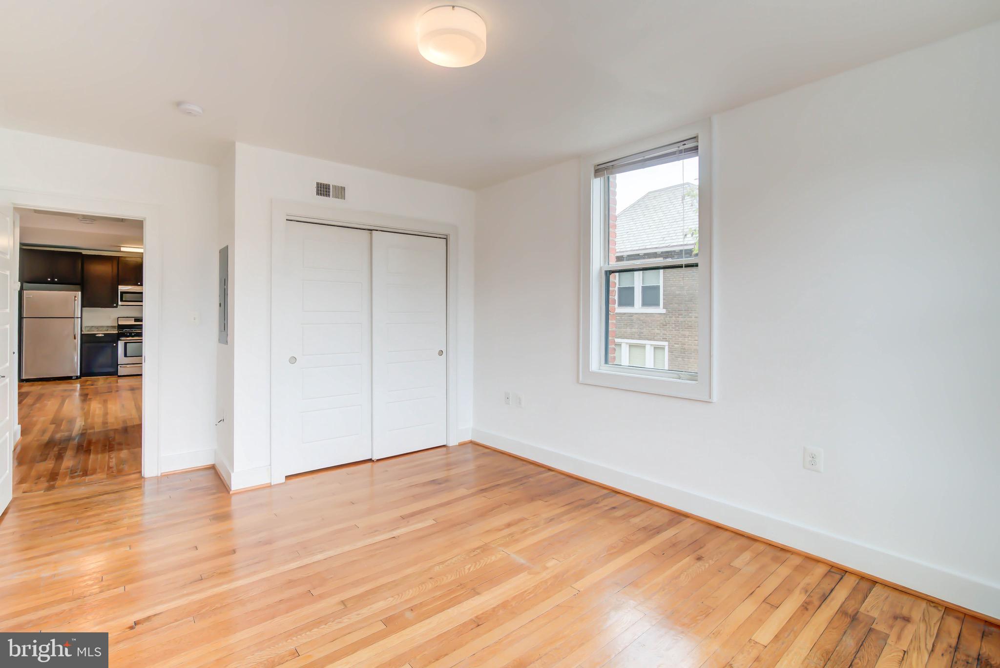 1575 Spring Place Northwest, Unit 35 Washington, DC 20010 - Photo 13 of 22 wooden floor in an empty room with a window