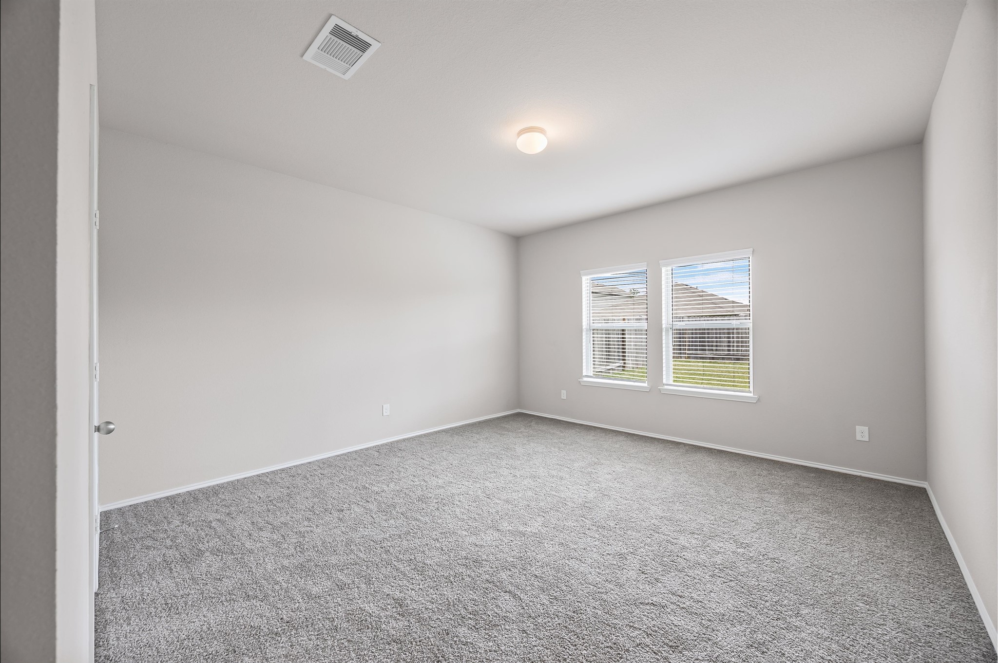 23522 Wedgewood Cliff Way Spring, TX 77373 - Photo 19 of 30 Another secondary bedroom features neutral walls, plush new carpeting, and two windows providing natural light. It's spacious and versatile, ideal for a bedroom or office.