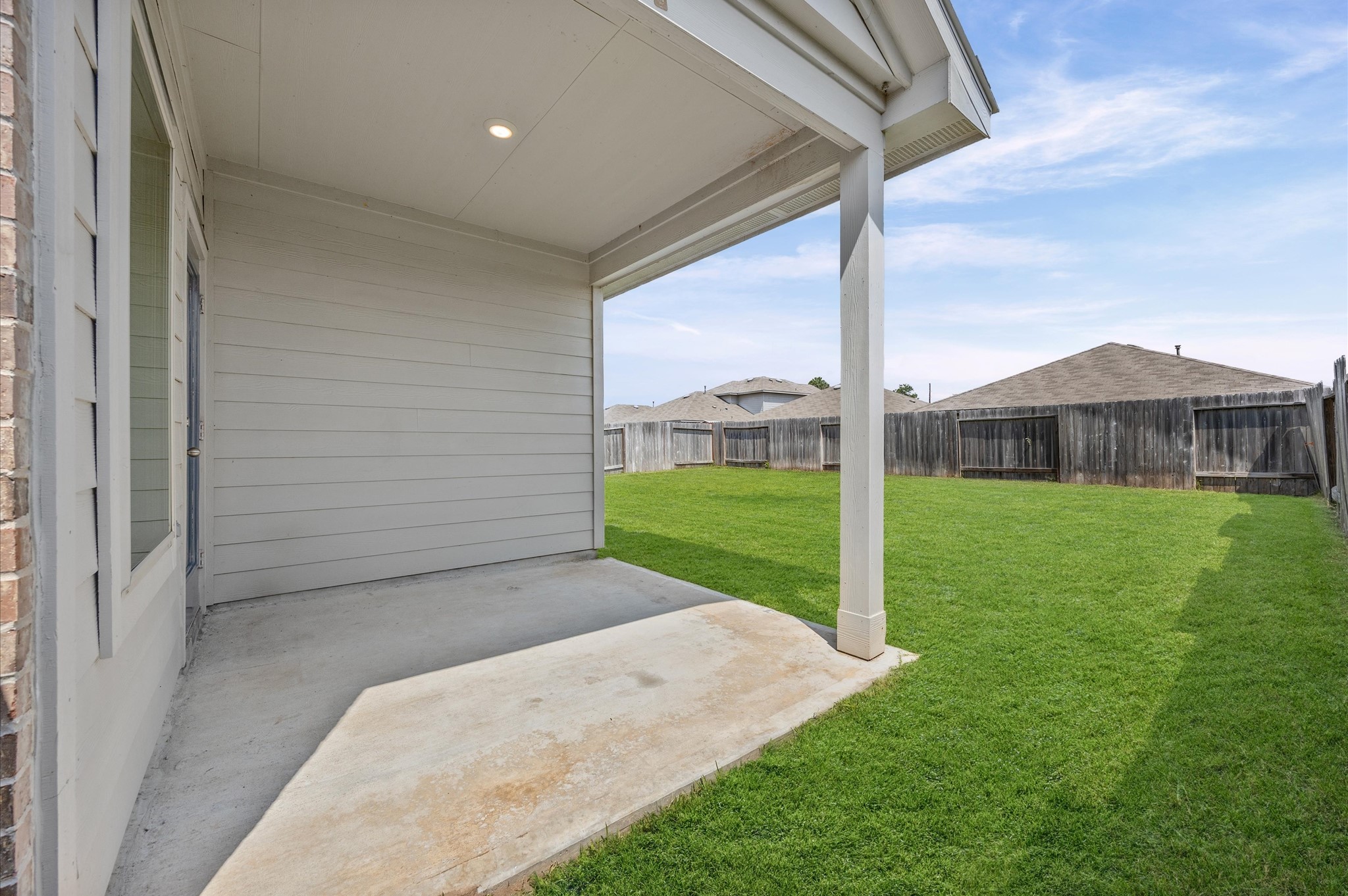 23522 Wedgewood Cliff Way Spring, TX 77373 - Photo 30 of 30 Covered patio area with a concrete floor, leading to a spacious, fenced backyard ideal for outdoor activities and relaxation.