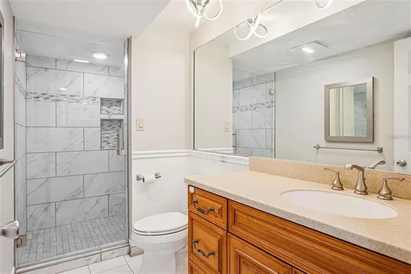 a bathroom with a granite countertop sink toilet and shower
