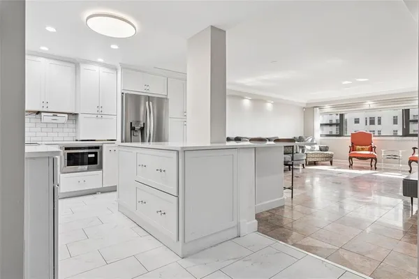 a large white kitchen with cabinets