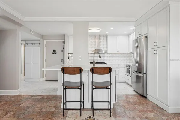 a kitchen with stainless steel appliances kitchen island granite countertop a refrigerator and a dining table