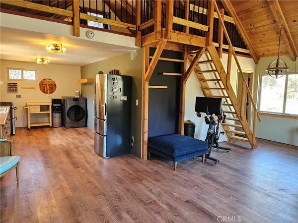 a kitchen with stainless steel appliances a stove a refrigerator a sink and dishwasher with wooden floor