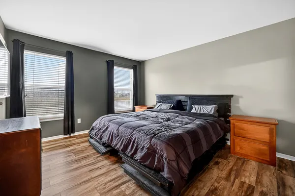 a bedroom with a bed and wooden floor