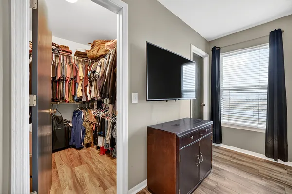 a view of walk in closet with clothes and shoes