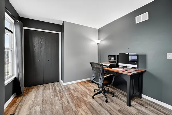 a view of a workspace with furniture and wooden floor
