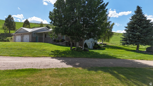 9029 North Treasureton Road Preston, ID 83263 - Photo 28 of 31 Exterior featuring a two-car garage with white doors, light gray siding, and stone accents