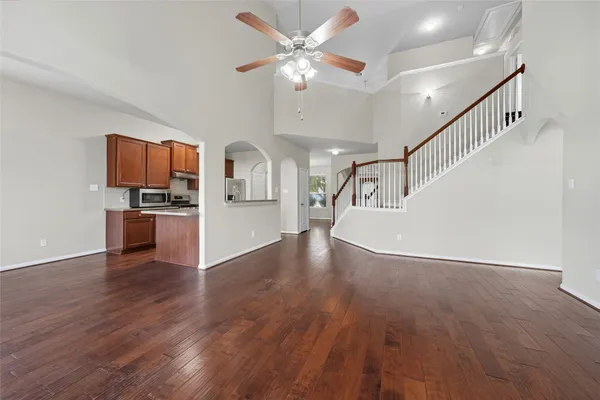a view of a kitchen with wooden floor and a ceiling fan