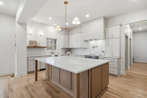 a large kitchen with kitchen island a sink counter space appliances and a living room view