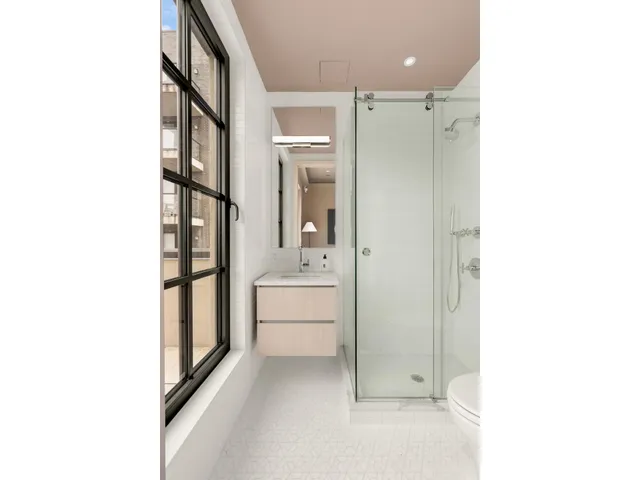 a bathroom with a glass door shower a sink and a mirror