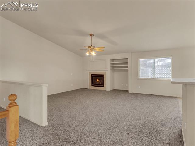8599 Tibbs Road Peyton, CO 80831 - Photo 11 of 38 Spacious family room with vaulted ceiling, gas fireplace, entertainment inserts and is open to the kitchen area
