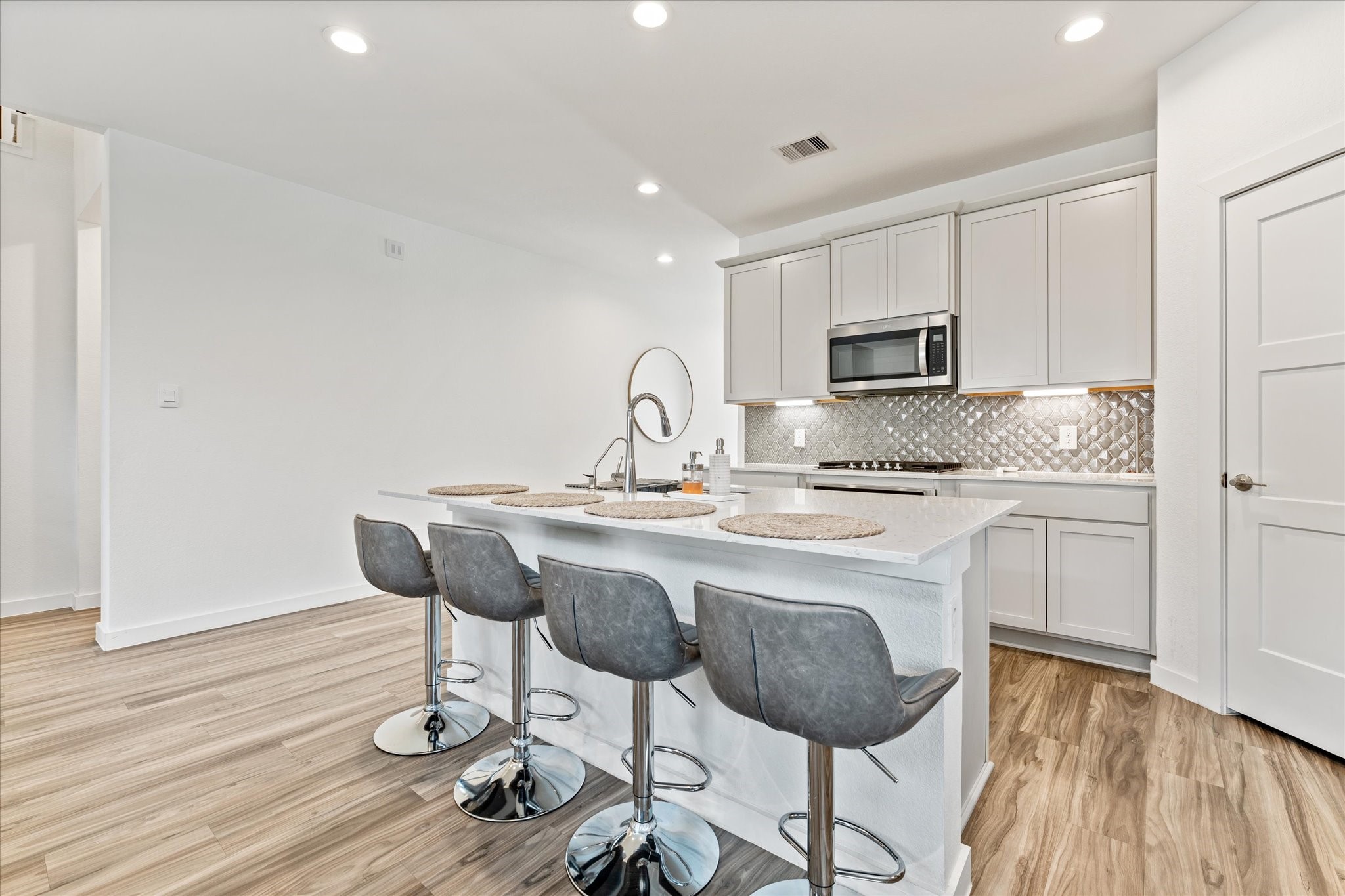 10212 Prairie Creek Lane Conroe, TX 77384 - Photo 11 of 41 a kitchen with kitchen island a dining table chairs cabinets and wooden floor