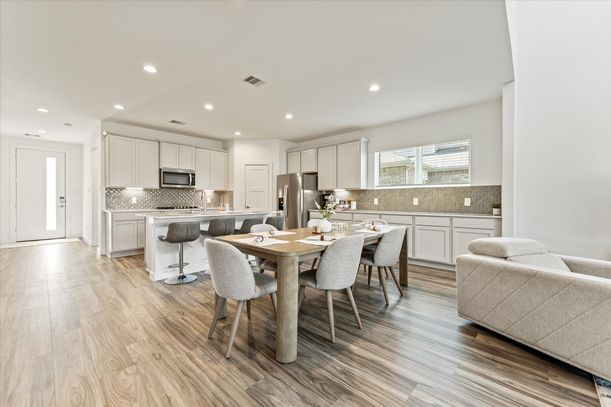 10212 Prairie Creek Lane Conroe, TX 77384 - Photo 17 of 41 a kitchen with a dining table chairs wooden floor appliances and cabinets