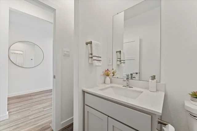 a kitchen with a dining table chairs and wooden floor