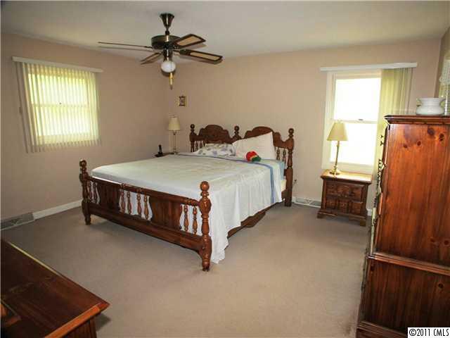 9601 Belt Road Midland, NC 28107 - Photo 12 of 16 a spacious bedroom with a bed and a chandelier