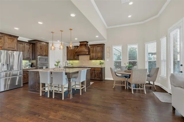 a living room with stainless steel appliances kitchen island granite countertop furniture and a wooden floor