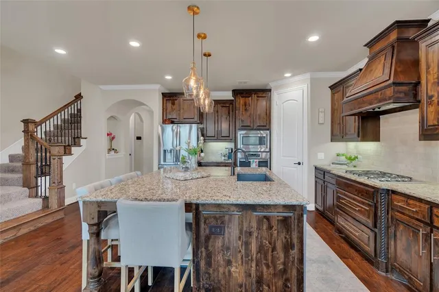 a dining room with stainless steel appliances wooden floors a table and chairs