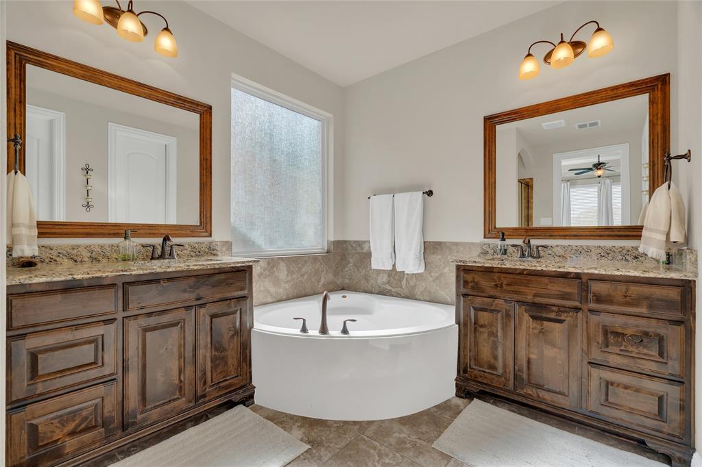 2852 Exeter Drive Trophy Club, TX 76262 - Photo 26 of 40 a bathroom with a granite countertop bathtub a sink and a mirror