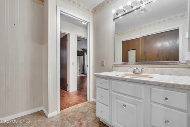 a bathroom with a granite countertop sink vanity and mirror