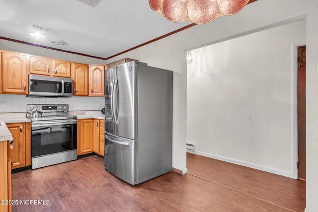 a kitchen with granite countertop a refrigerator and a stove top oven