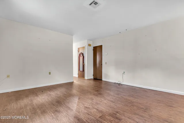 a view of an empty room and wooden floor