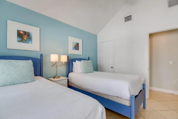 a bedroom with two beds and painting on the wall