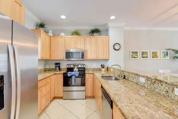 a kitchen with stainless steel appliances granite countertop a sink stove and refrigerator