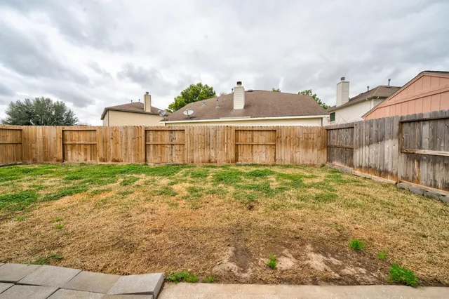 a view of a house with a yard and wooden fence