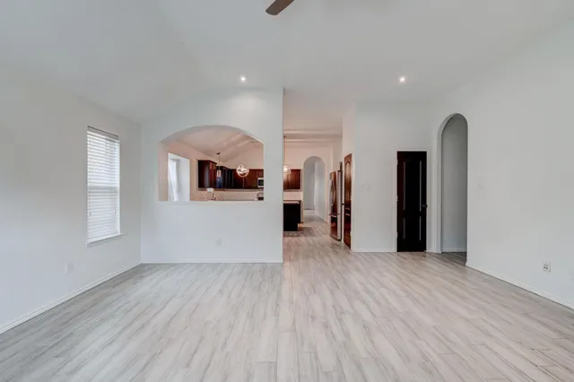 a view of a kitchen with an empty room and a window